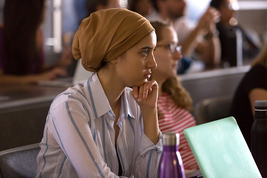 Student with hand to chin looking pensively during a meeting