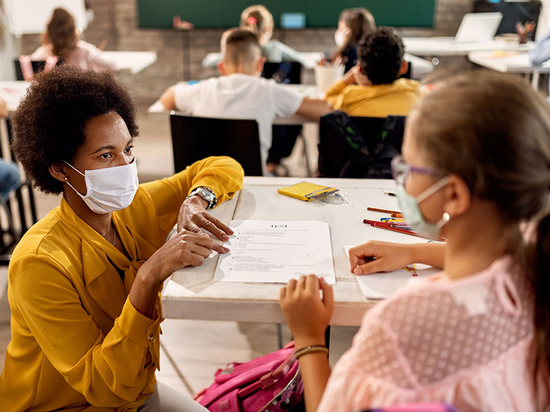 Teacher wearing face mask with student