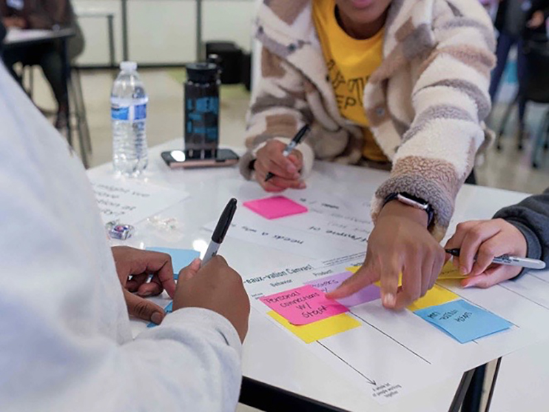Community participants (above) explore needs and values in a Phyllis M. Taylor Center for Social Innovation and Design Thinking design activity focused on empathy.