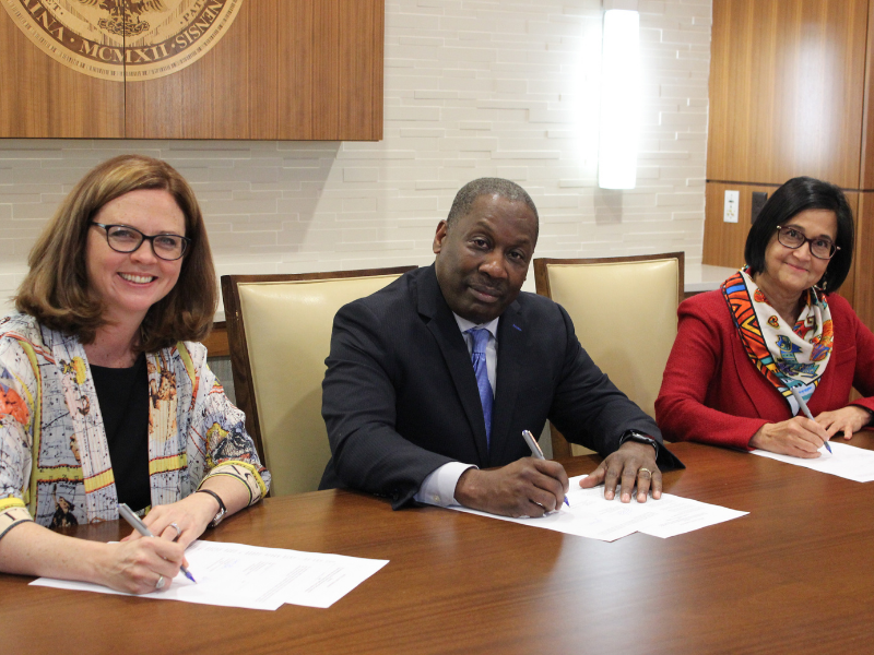 Photo of Dean LaVeist signing document at Loyola University 