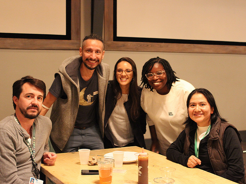 Group of young people pose at a table at alumni reception