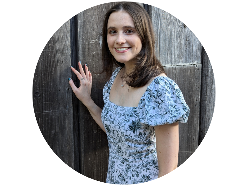 Alexandra Mack smiling, hand on a wooden fence