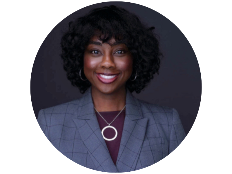 XEQUIERA WATKINS headshot, wearing a grey suit, and smiling directly at the camera