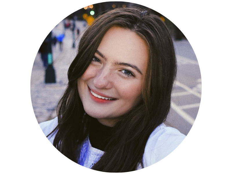 Emma Kolsch, a young woman with dark hair smiling warmly, blurred city street in background.