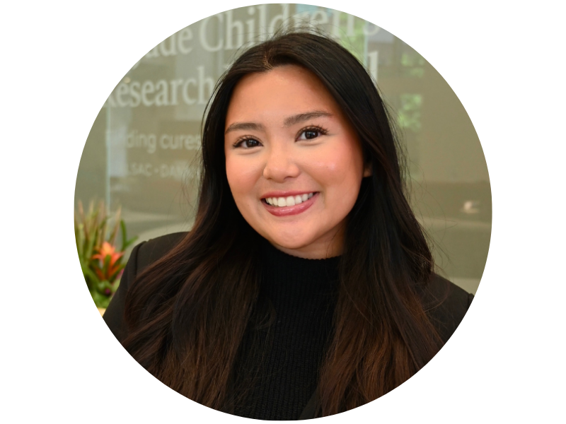 Mia Le, headshot, wearing a black turtleneck sweater and standing in front of s St. Jude's Children's Research Center sign