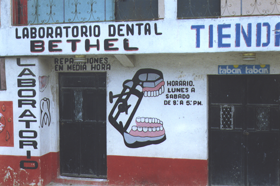 Dental lab in an unknown South American country, hand-painted sign of a set of teeth and dental tool