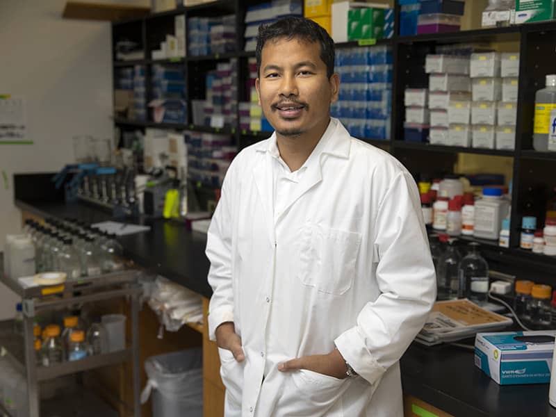 Photo of Dr. Samendra Sherchan standing in a lab.