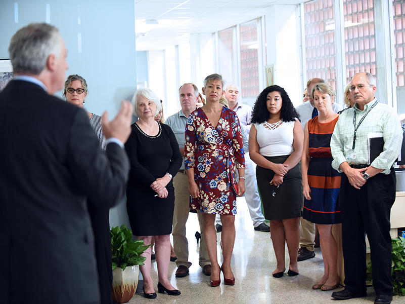 SPHTM and NCI faculty and staff look on as Tulane Provost Robin Forman talks about the collaboration.