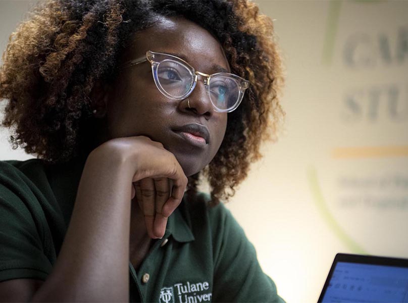 Young African-American woman looking thoughtfully at computer screen. Photo by Paula Burch-Celentano. 