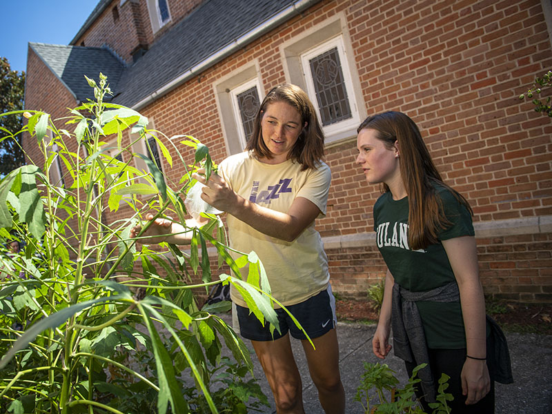 Two white female college students working in a Green Light Nola project community garden. Photo by Paula Burch-Celentano. 