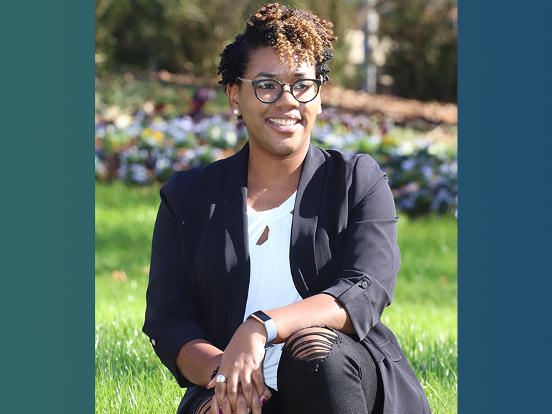 Chelsea Singleton, sitting, smiling, hands crossed