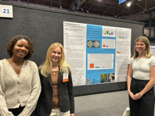 Mia MacDonald, Cheryl Cole, Caroline Hampson standing together with their poster