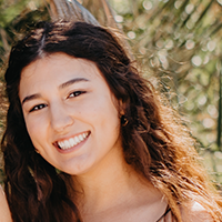 Photograph of Marisa Arsenault, smiling young woman with long, curly brown hair.