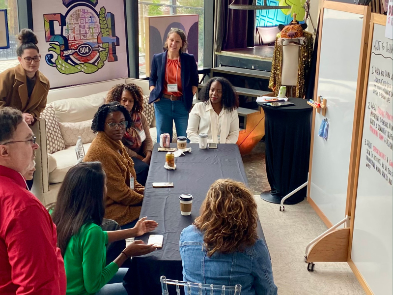 A group discuss AI and health equity in front of a white board.