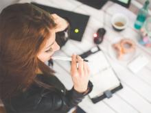 Woman in thought at a desk. Stock photo. 