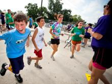 Children exercise on playground with Tulane Volunteers  